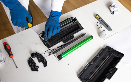 hands repairing laser toner cartridge. worker Laser printer on a workbench.