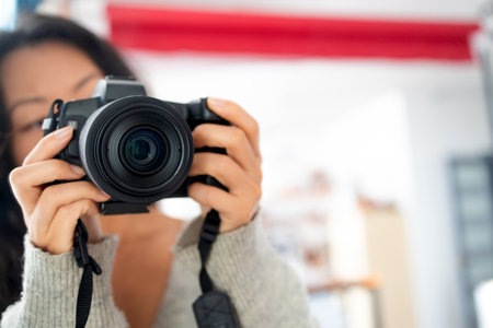 Young female photographer with a camera on a soft background taking pictures with her new cameraの写真素材