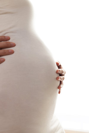 Pregnant woman standing by the windowの写真素材