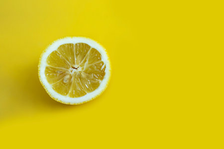 One lemon slice isolated on yellow background.の写真素材