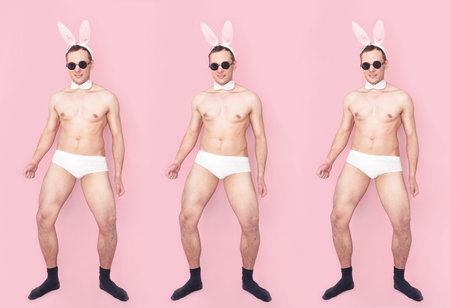 Full body portrait of sexy playful cheerful man wearing fluffy ears having fun isolated over pink pastel color background.の写真素材