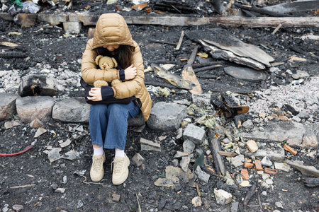 A girl next to a house destroyed by the war. War in Ukraine. Ukrainian refugees. Child in the ruins of his house destroyed by the war. peace conceptの写真素材