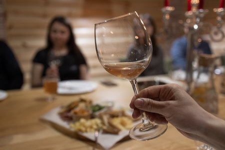 Glass of white wine in hand.