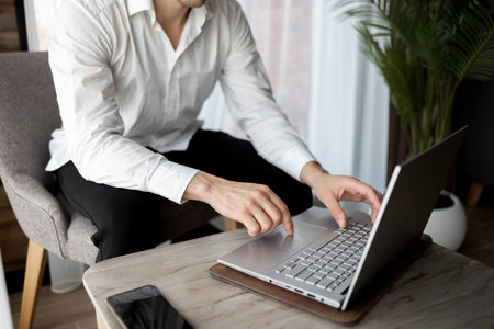 Businessman working on new project with notebook computer, digital tablet on table at office. Business man sitting at desk, hands typing on notebook computer, close upの写真素材