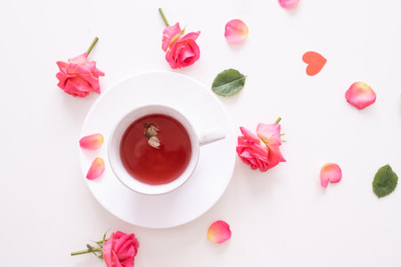 Cup of tea with pink rose on white background. top view. copyspace.の写真素材