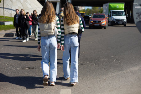 twins girls wearing same clothes are walking down the street