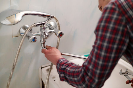 Plumber hands fixing water tap with spannerの写真素材