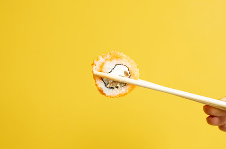 Sushi roll with salmon, shrimps and avocado on yellow background.の写真素材