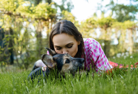 Beautiful young woman playing with her young dog in the park outdoors. life style portrait.