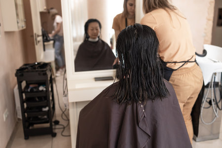 Hairdresser trimming brown hair with scissors. Woman cutting hair with barber scissors in beauty studio. Hair Stylist doing female haircut in hairdressing salon. Beauty and style cの写真素材