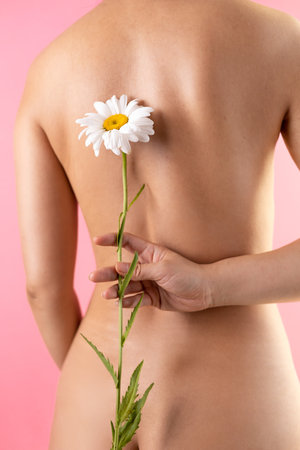 Beautiful naked woman with flower on pink background, closeupの写真素材