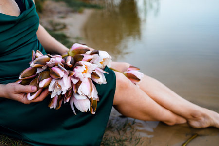 Beautiful girl in a green dress with a bouquet of flowersの写真素材