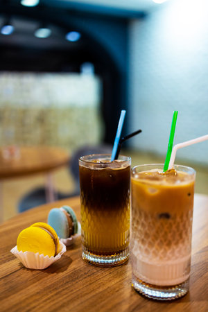Iced coffee with macaroon on wooden table in coffee shop