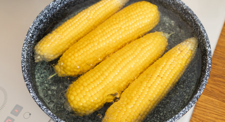 Boiled corn cobs in hot pan on the gas stove.の写真素材