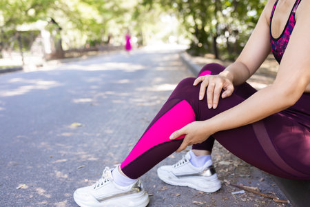 Young adult woman with muscle pain while running. A runner has a sore foot due to plantar fasciitis....