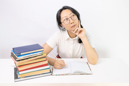 Portrait of an Asian female student studying at the desk with books