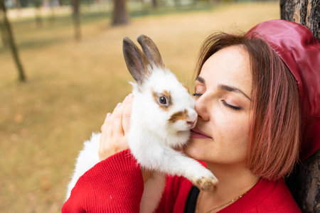 Portrait of a young woman with a rabbit in the park.の写真素材