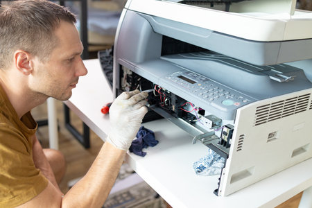Repairman repairing a photocopier at the repair shop.