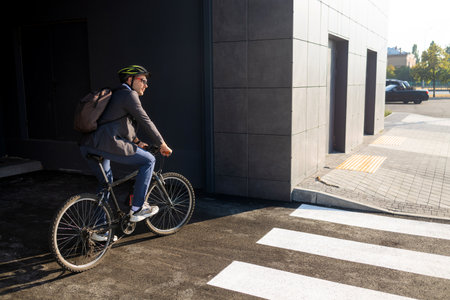 Handsome young adult man wearing suit riding his classic bicycle to work in the morning. Businessman...