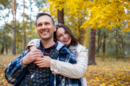 Couple in love in the autumn park. A man and a woman are hugging and smiling.の写真素材