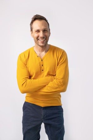 Portrait of a handsome young man in yellow sweater, isolated on white background