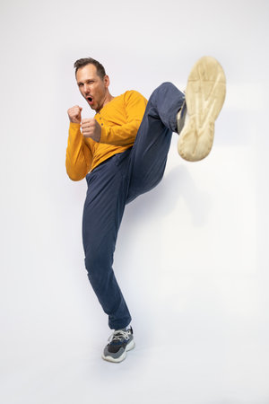 Full length portrait of a young man fighting and gesturing over white background