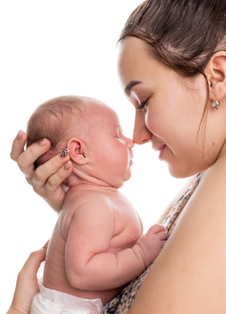 Mother kissing her newborn baby. Isolated on a white background.の写真素材