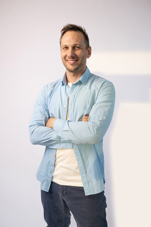 Handsome man in blue shirt smiling at the camera on white backgroundの写真素材