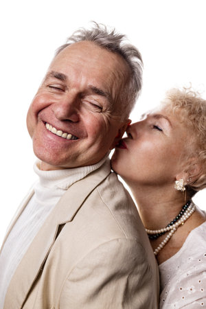 Elderly couple embracing each other on white background. Studio shot.