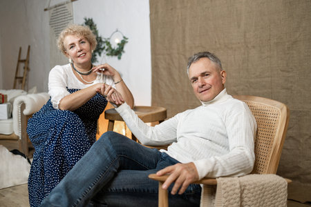 Portrait senior couple in living room in home, smiling. Love, retirement and smile of happy elderly man and woman on sofa, embrace and enjoying quality time together in house.の写真素材