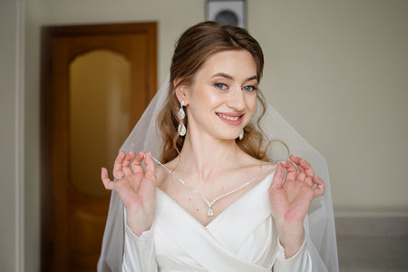 Portrait of a beautiful bride in a white dress with a veilの写真素材