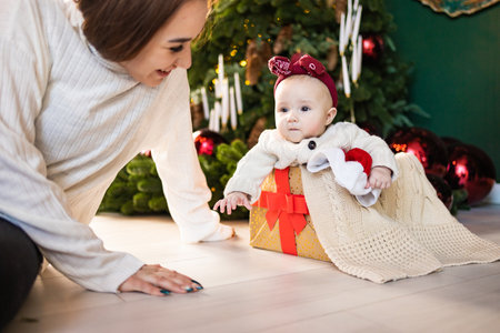 Mother and baby girl with christmas gifts in a room decorated for Christmasの写真素材