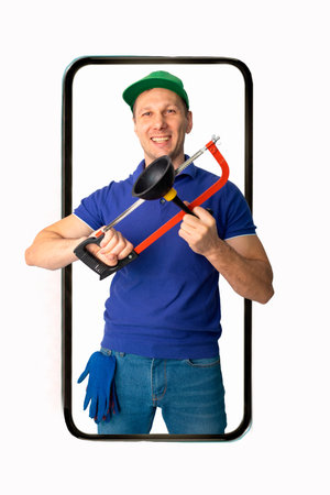 Cheerful repairman holding a plunger in a smartphone videocall and smiling, online service conceptの写真素材