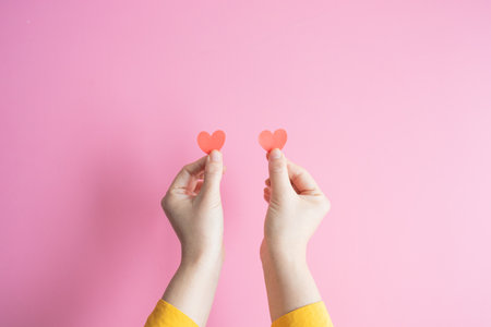 Demonstration of love. female hands are holding two red hearts. hands get likes on social networks. Valentines day international women.の写真素材