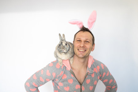 Portrait of funky positive man wear pink bunny costume with gray rabbit impressed staring isolated on white background.の写真素材