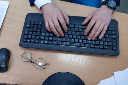 Businessman typing on computer keyboard in office. Close-up of hands.の写真素材