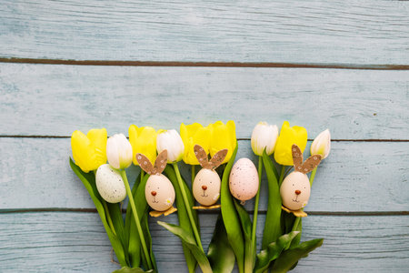 Easter eggs and tulips on blue wooden background with copy spaceの写真素材