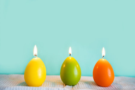 Easter candles on a blue background with copyspace for textの写真素材