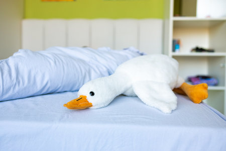 White duck on the bed in the children's room, soft focus backgroundの写真素材