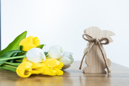 Bouquet of tulips and wooden toy bunny on a wooden tableの写真素材