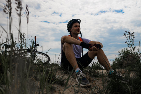Cyclist Resting After Riding Bike On Dirt Road In Summerの写真素材