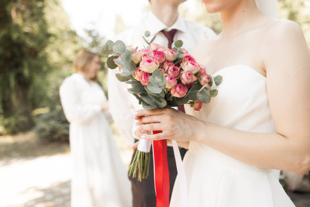Beautiful wedding bouquet in hands of the bride and groom.の写真素材