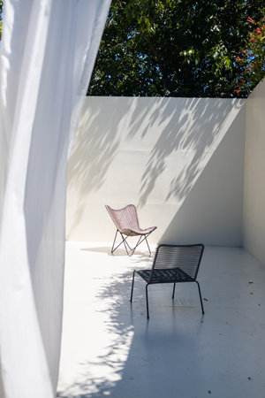 Outdoor patio with chair and white curtain in the garden, summer dayの写真素材