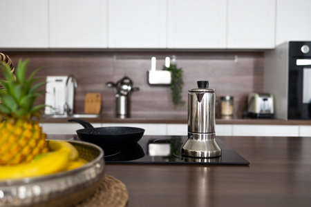 Stainless steel coffee pot on a wooden table in the kitchen