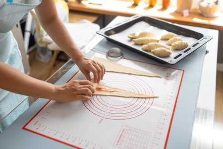 hands Preparing uncooked croissants for baking bakery conceptの写真素材