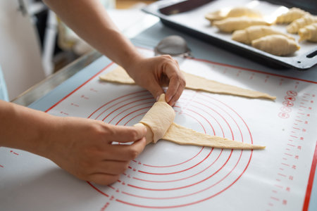 Close-up of female hands kneading dough for croissantsの写真素材