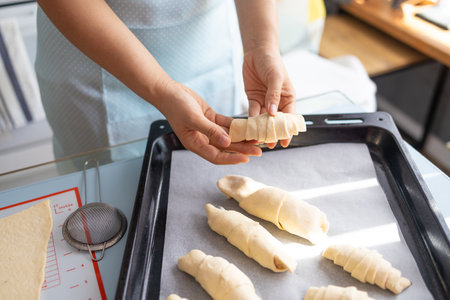 cropped shot of woman making croissants in kitchen at home