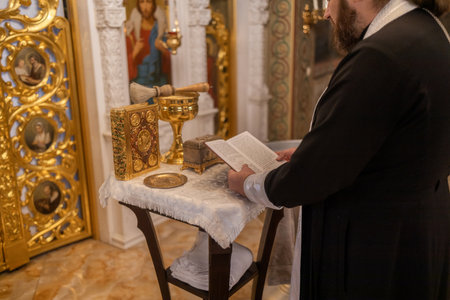 Priest reading the bible in the Orthodox Church during a religious ceremonyの写真素材