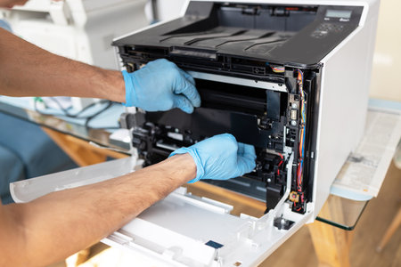 Close-up of a male technician fixing a printer in his officeの写真素材