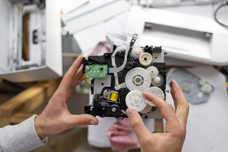 worn gear from the printer reducer in the hands of the master, closeup. Maintenance support and...